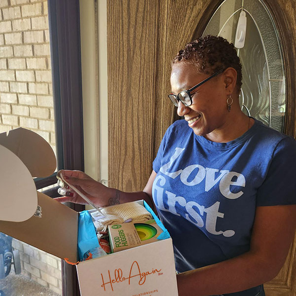 A happy client receiving a Hello Again Box from their real estate agent